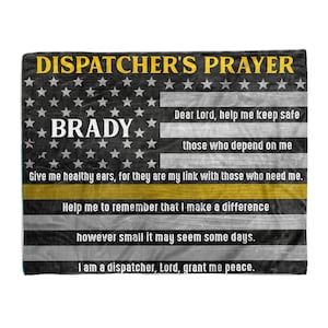 May include: A black and white American flag with a yellow stripe across the middle. The text "DISPATCHER'S PRAYER" is at the top of the flag. The text "BRADY" is in the middle of the flag. The text "Dear Lord, help me keep safe those who depend on me. Give me healthy ears, for they are my link with those who need me. Help me to remember that I make a difference however small it may seem some days. I am a dispatcher, Lord, grant me peace." is on the right side of the flag.