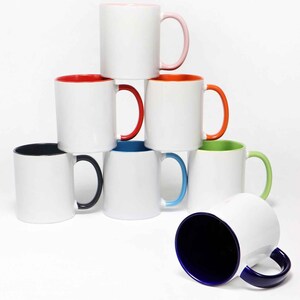 May include: A stack of white ceramic mugs with colored interiors and handles. The mugs have a variety of colors, including pink, red, orange, green, blue, and black. The mugs are stacked in a pyramid shape.