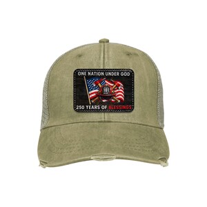 May include: A distressed olive green trucker hat with a mesh back. The front patch features the text "ONE NATION UNDER GOD" and "250 YEARS OF BLESSINGS" with a patriotic design including a firefighter's helmet, American flag, and crossed axes.