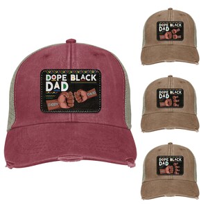 May include: A burgundy and khaki trucker hat with a distressed look. The front patch reads "DOPE BLACK DAD" with two fists bumping and the names "Daddy" and "David". The hat has a mesh back and a curved brim.