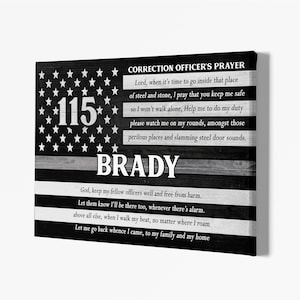 May include: Black and white wooden sign with an American flag design and the text "CORRECTION OFFICER'S PRAYER" and "*115* BRADY". The sign includes a prayer for a correction officer.