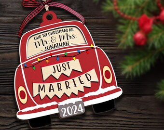 Può includere: Addobbo natalizio in legno rosso a forma di auto con il testo "Our 1st Christmas as Mr. & Mrs. -Jonathan- Just Married 2024" su di esso.
