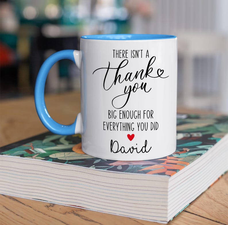 May include: White ceramic mug with a blue interior and handle. The mug features the text "There isn't a Thank you big enough for everything you did" in black script, with a red heart and the name "David" below.