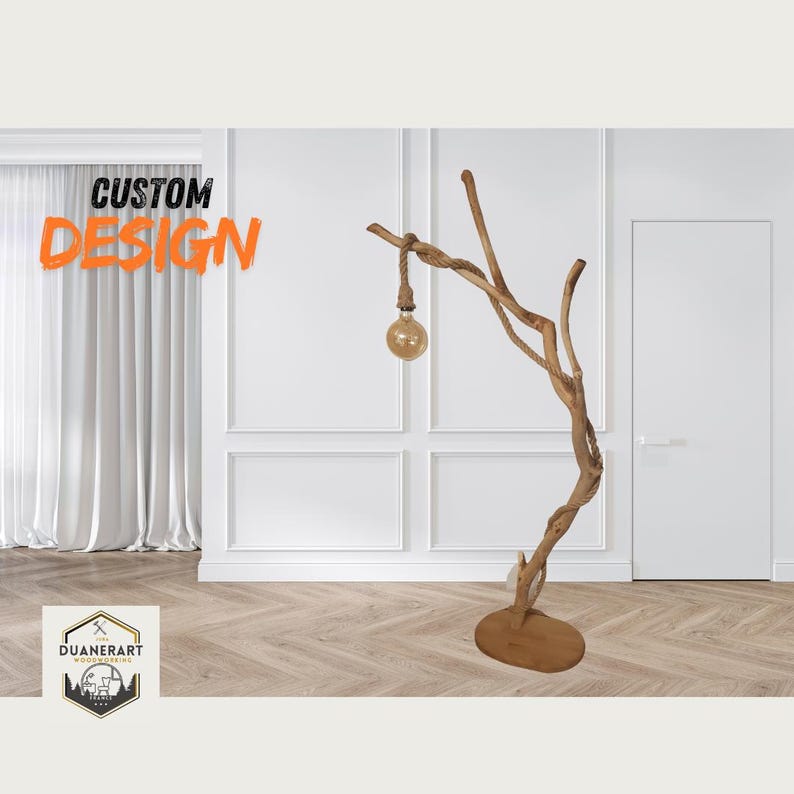 May include: A custom designed floor lamp made from a natural tree branch with a rope wrapped cord and a light bulb. The lamp is on a wooden base and is in a room with white walls and wood floors.