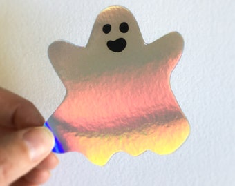 May include: A holographic iridescent ghost sticker with a black smiling face.