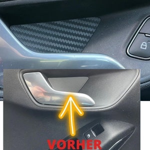 Op de afbeelding: Een close-up van een autodeurpaneel met een zilveren deurgreep en een zwarte carbonfiber-achtige afwerking. Het paneel heeft ook een zilveren knop met een slotpictogram. De tekst "VORHER" is zichtbaar in de rechterbenedenhoek van de afbeelding.