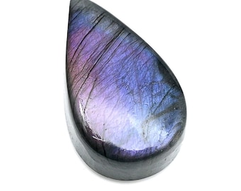 May include: A teardrop-shaped gemstone with a polished surface. The stone displays a gradient of colors, including purple, blue, and gray, with subtle lines across the surface. The gemstone is set against a white background.