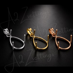 Può includere: Tre montature per pendenti a forma di goccia in argento, oro e oro rosa. Ogni montatura ha un anello per una catena e tre griffe per tenere una pietra preziosa. Le montature sono esposte su uno sfondo scuro.
