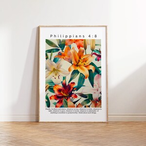 Może przedstawiać: Wydruk w ramie z kwiatowym wzorem przedstawiającym lilie w odcieniach pomarańczowego, czerwonego, białego i różowego. Wydruk zawiera tekst "Philippians 4:8" i cytat z wersetu biblijnego.