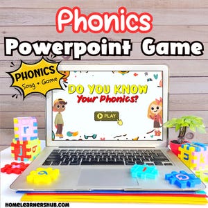 May include: A laptop displays a "Phonics PowerPoint Game" with the text "Do You Know Your Phonics?". Colorful letter-shaped toys and a small plant are arranged around the laptop. The words "Phonics" and "Powerpoint Game" are written in red.