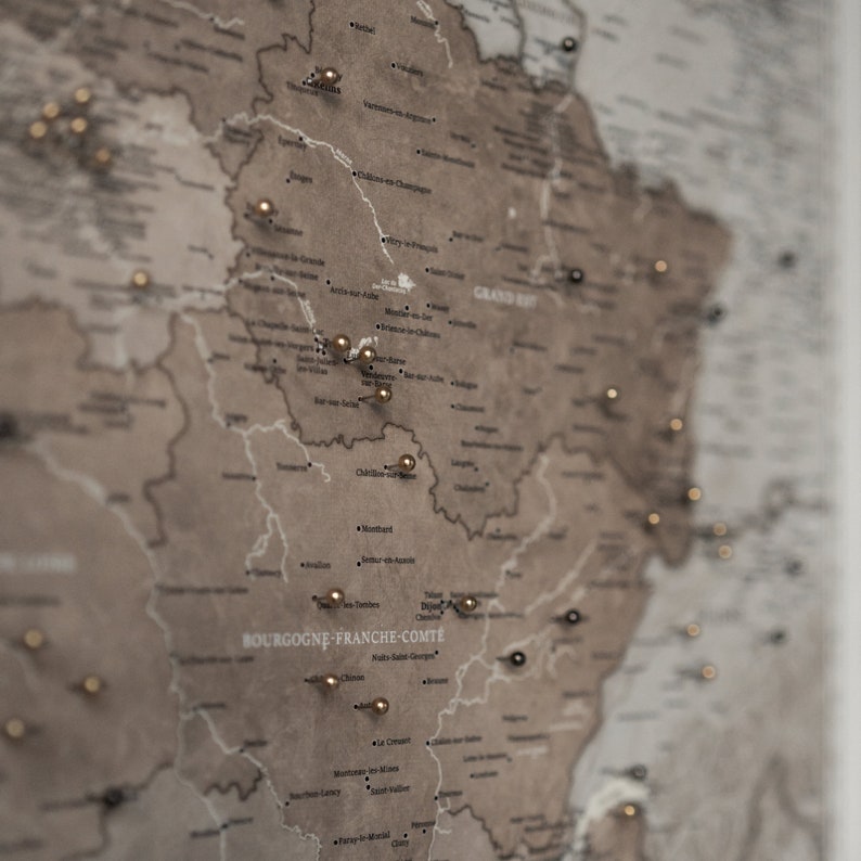 Carte de France à épingler sur toile avec des épingles montrant les voyages et les destinations.