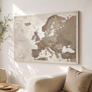 Peut inclure: Une carte murale rectangulaire de l'Europe présentant une palette de couleurs neutres composée de beige, de crème et de diverses nuances de brun. La carte affiche des frontières géographiques détaillées, des côtes et des noms de pays.