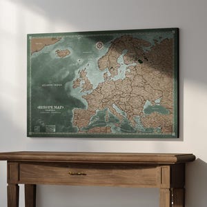 Könnte beinhalten: Eine rechteckige Wandkarte von Europa mit einem tiefgrünen Ozeanhintergrund und braunen Landmassen. Die Karte enthält den Text EUROPE MAP, TRAVELS sowie verschiedene geografische Bezeichnungen. Sie ist dunkel umrandet und detailliert.