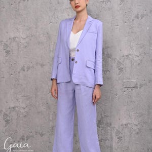 Front portrait shot of a model standing in a custom-tailored 200gsm purple linen suit, emphasizing the classic padded shoulders and structured look from the inner cotton lining.