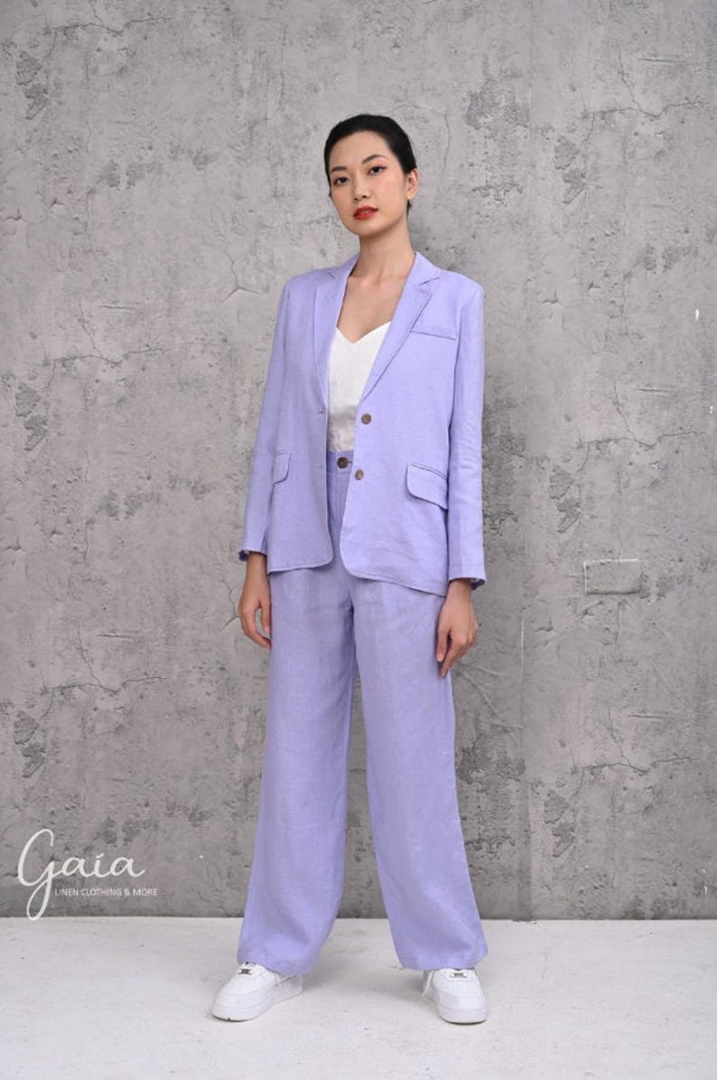 Front portrait shot of a model standing in a custom-tailored 200gsm purple linen suit, emphasizing the classic padded shoulders and structured look from the inner cotton lining.