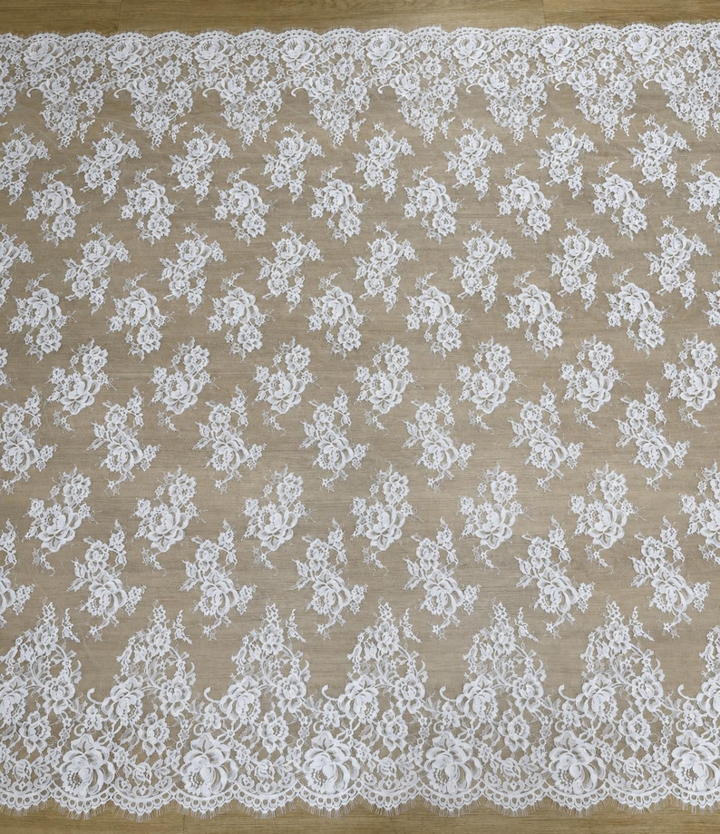 Beige lace wedding gown fabric swatch with white floral lace and scalloped edges