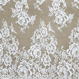 White lace fabric with white floral embroidery and a scalloped edge, perfect for a lace wedding gown.