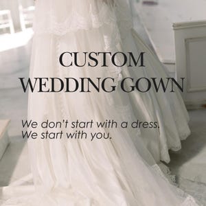 May include: A white wedding gown featuring delicate lace trim and a flowing skirt. The text CUSTOM WEDDING GOWN is centered, followed by the phrase We don't start with a dress. We start with you. The gown has a long train and a soft, layered appearance.
