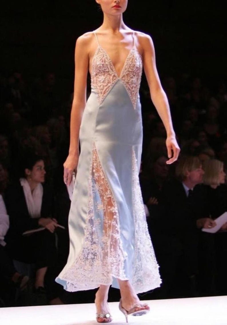 Full-length runway shot of a model showcasing the light blue silk slip dress, capturing the effortless movement, airy comfort, and couture-inspired elegance.