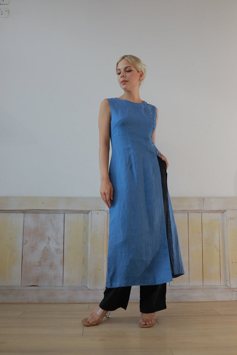Full-body front view of the model standing confidently against a plain wall backdrop, capturing the complete elegant silhouette and creative contemporary lifestyle vibe of the ensemble.