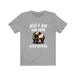 May include: Grey t-shirt with a white graphic of a wolverine and the text "Just a boy who loves Wolverines".