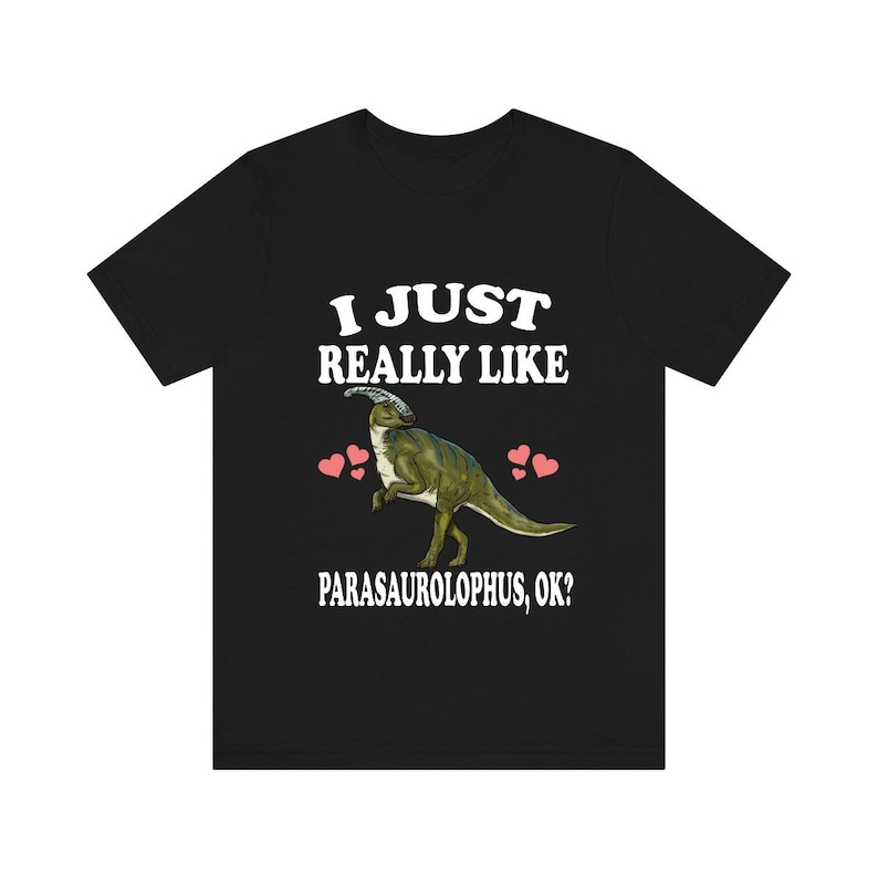 May include: Black t-shirt with white text that reads "I just really like Parasaurolophus, ok?" and a cartoon image of a Parasaurolophus dinosaur with pink hearts.
