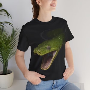 May include: A black short-sleeve t-shirt featuring a large, detailed graphic print of a green snake with its mouth wide open. The snake has textured scales, visible eyes, and a dark interior to its mouth, centered prominently on the front of the shirt.