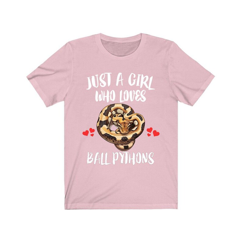 K&ouml;nnte beinhalten: Hellrosa T-Shirt mit dem wei&szlig;en Schriftzug "JUST A GIRL WHO LOVES BALL PYTHONS". Das Shirt zeigt eine Grafik einer K&ouml;nigspython und kleine rote Herzen.