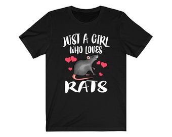 Peut inclure: T-shirt noir avec l'inscription blanche "JUST A GIRL WHO LOVES RATS". Une illustration de rat gris est entourée de coeurs roses. Le t-shirt est fait d'une matière douce.