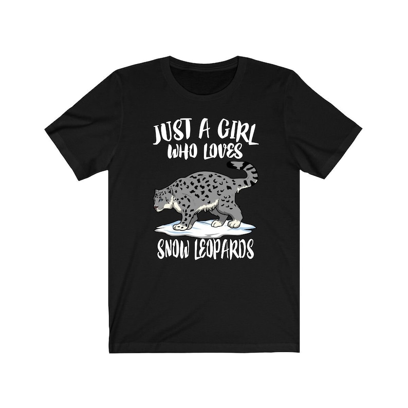 May include: Black t-shirt with white text that reads "Just a girl who loves snow leopards". A cartoon snow leopard is pictured on the shirt.