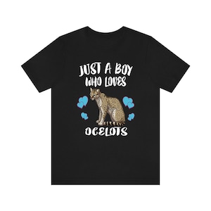 Może przedstawiać: Czarny T-shirt z białym nadrukiem, który mówi "Just a boy who loves ocelots" z kreskówkowym ocelotem i niebieskimi sercami.