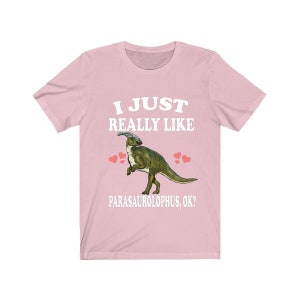 May include: Pink t-shirt with a white graphic of a Parasaurolophus dinosaur with the text "I just really like Parasaurolophus, ok?"
