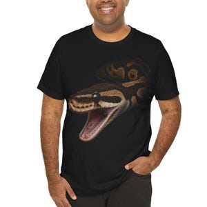 May include: A black short-sleeved t-shirt featuring a large, detailed graphic of a brown and black patterned snake with its mouth wide open. The snake's head and coiled body are centered on the chest, displaying realistic scales and textures.