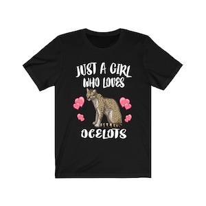 Może przedstawiać: Czarny T-shirt z białym nadrukiem, który mówi "Just a girl who loves ocelots" z kreskówkowym ocelotem i różowymi sercami.