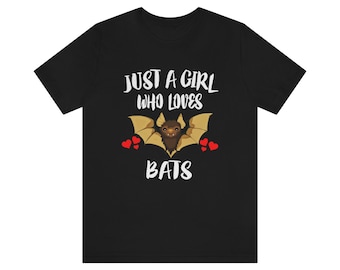 May include: Black t-shirt with white text that reads "Just a girl who loves bats". A brown bat with red hearts is pictured on the shirt.