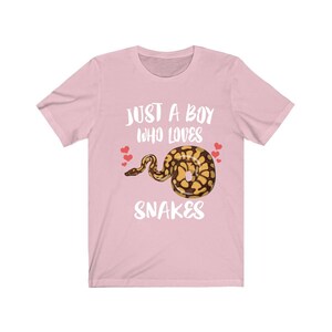 May include: Pink t-shirt with the text "Just a boy who loves snakes" and a cartoon image of a snake with hearts.