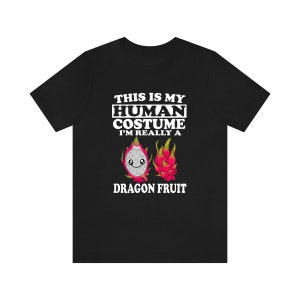 May include: Black t-shirt with white text that reads "This is my human costume I'm really a dragon fruit". The text is surrounded by a cartoon image of a dragon fruit.