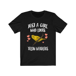 Könnte beinhalten: Schwarzes T-Shirt mit weißem Text, der "Just a girl who loves yellow warblers" lautet. Ein gelber Goldammer sitzt auf einem Ast mit rosa Herzen drumherum.