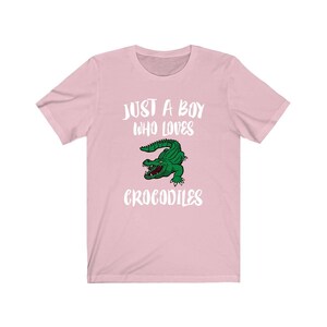 May include: Pink t-shirt with a white graphic that says "Just a boy who loves crocodiles" and a cartoon crocodile.