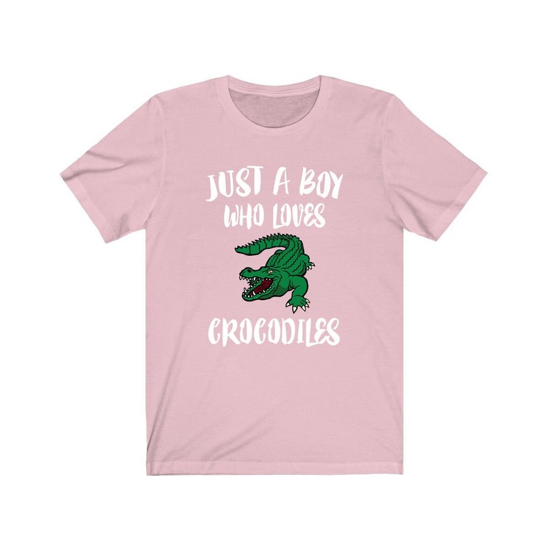 May include: Pink t-shirt with a white graphic that says "Just a boy who loves crocodiles" and a cartoon crocodile.