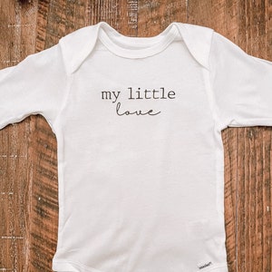 May include: White long-sleeved baby onesie with the text "my little love" printed on the front.