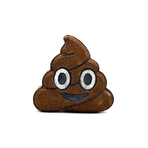 May include: A brown poop emoji bath bomb with a white smiling face and two large white eyes.