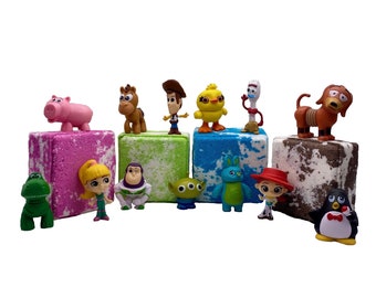 May include: A set of eight bath bombs featuring various Toy Story characters, including Woody, Buzz Lightyear, Jessie, and Rex. Each bath bomb is a different color and has a unique design.