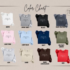 May include: A color chart displays various crewneck sweatshirts in different colors, including white, black, and red. Each sweatshirt features the text "Digs on the Villain" in a script font. The chart is labeled "Color Chart."
