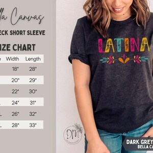Puede incluir: Camiseta de manga corta con cuello redondo Bella Canvas gris oscuro jaspeado. La palabra "LATINA" est&aacute; impresa en la parte delantera en letras coloridas con detalles florales. La tabla de tallas muestra medidas en cm para tallas S a 3XL.