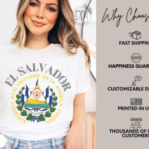 May include: A white short-sleeve t-shirt featuring the coat of arms of El Salvador in the center, surrounded by the text "REPUBLICA DE EL SALVADOR EN LA AMERICA CENTRAL" and "EL SALVADOR" in a circular arc above the national emblem.