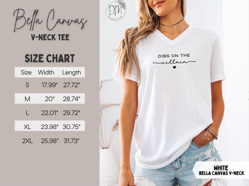 May include: White Bella Canvas V-neck tee with the phrase "Dibs on the villain" in black script. The image includes a size chart with measurements in inches. The shirt is a V-neck style.