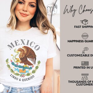 May include: A white short-sleeved t-shirt featuring a graphic of the Mexican coat of arms with an eagle perched on a cactus holding a snake. The text MEXICO and LINDO & QUERIDO is printed in black. The shirt is shown in a white color option.