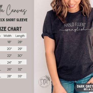 K&ouml;nnte beinhalten: Dunkelgraues Heather Bella Canvas Crewneck-Kurzarm-T-Shirt. Das Shirt tr&auml;gt den wei&szlig;en Schriftzug "HABLO FLUENT spanglish". Eine Gr&ouml;&szlig;entabelle ist enthalten, mit Gr&ouml;&szlig;en von S (45,7 cm Breite, 71,1 cm L&auml;nge) bis 3XL (71,1 cm Breite, 83,8 cm L&auml;nge).