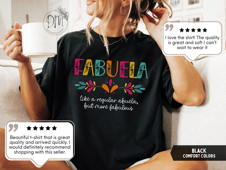 May include: Black comfort colors t-shirt with the word "FABUELA" in colorful letters. The shirt also has the phrase "like a regular abuela, but more fabulous" in white text. The shirt is a comfortable fit.